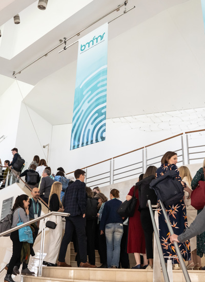 Business professionals on modern white staircase with metal railings at corporate event or conference venue