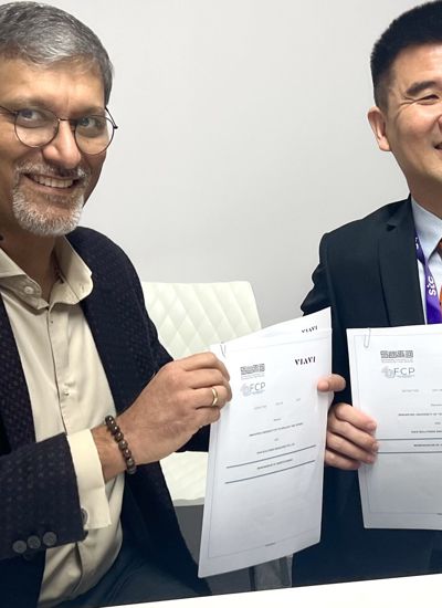 Two men holding up paper tickets with VIAVI printed on them