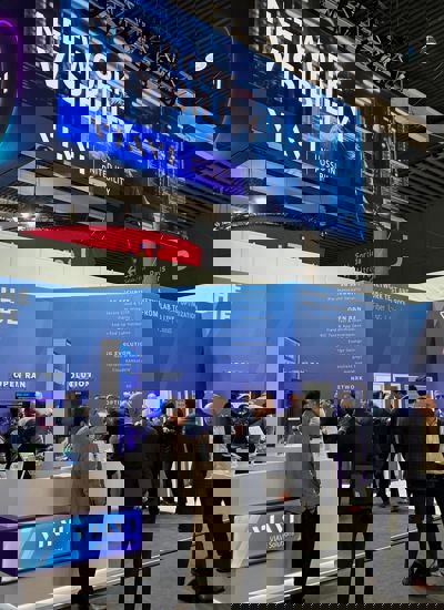 People standing around a tradeshow booth displaying the VIAVI brand