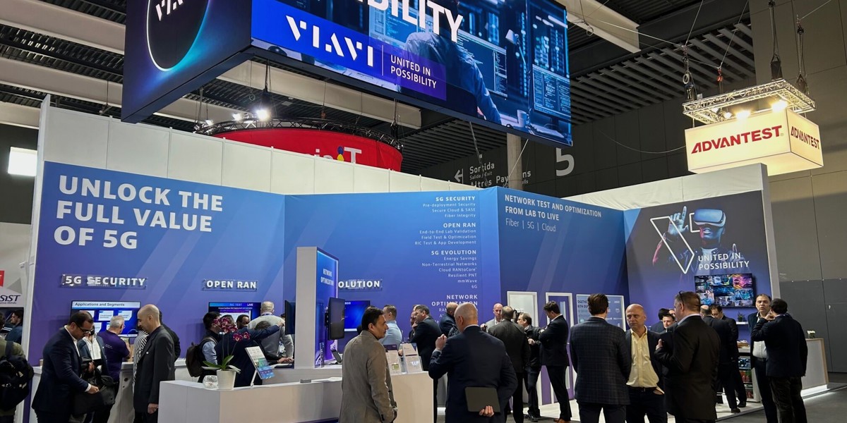 Crowded trade show booth with blue LED displays, networking equipment demos, and business professionals gathered at technology conference