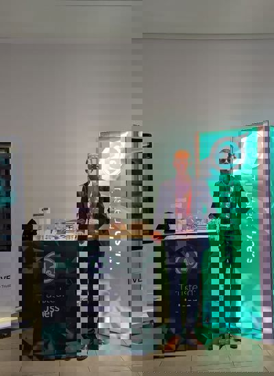 A man standing next to a tradeshow display called Trusted Users