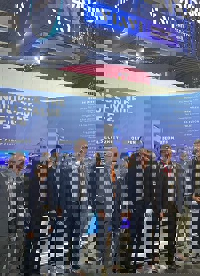A group of men standing in front of a tradeshow booth displaying the VIAVI brand