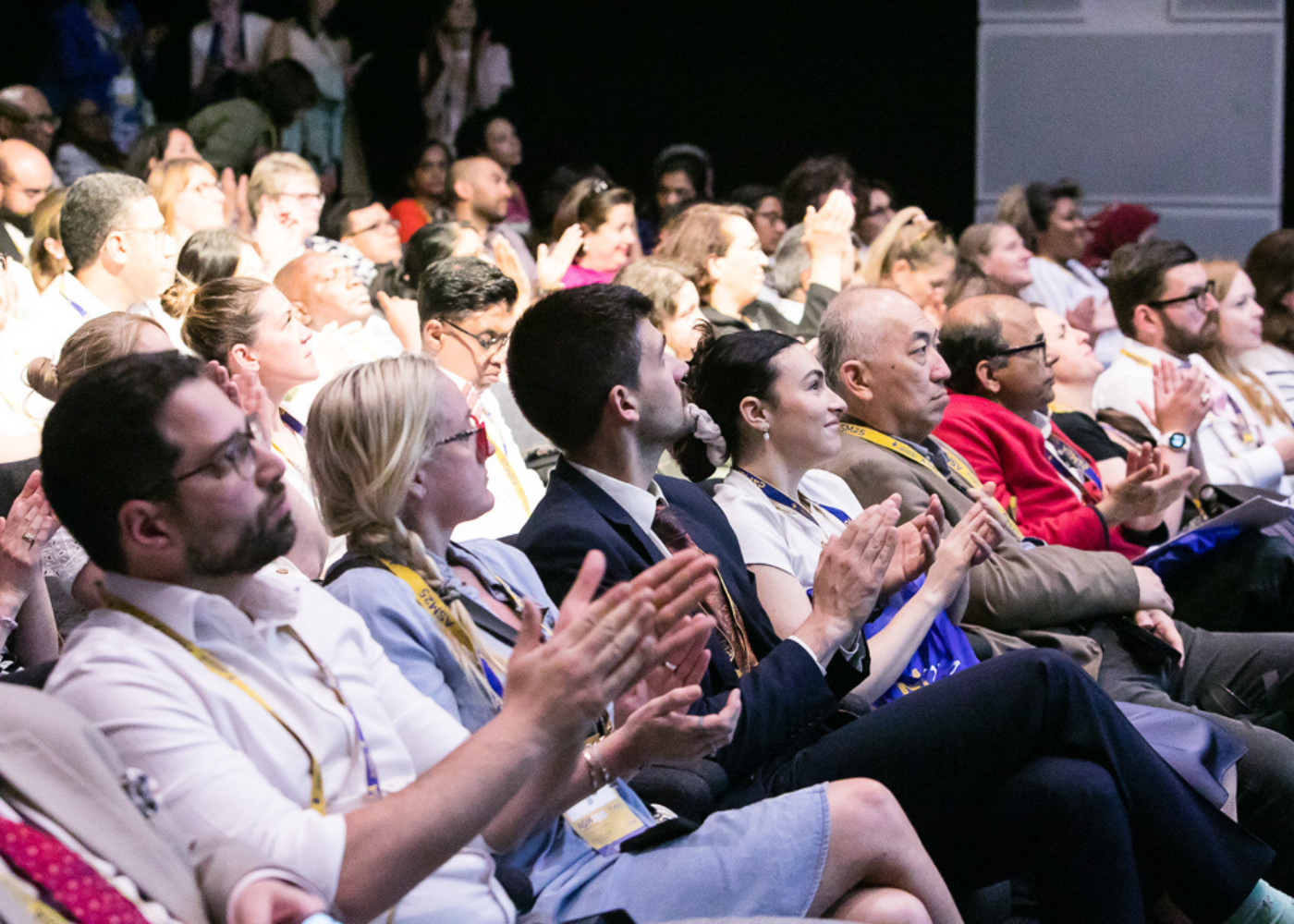 People seated and clapping during a presentation