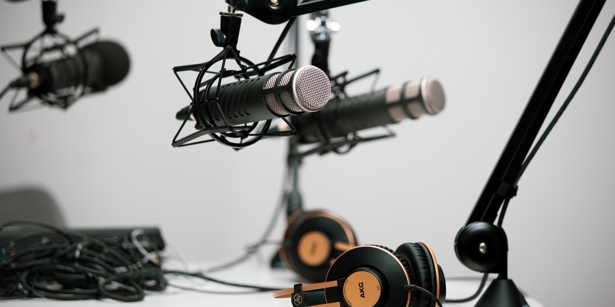 Podcast microphones surrounded by various tech equipment.