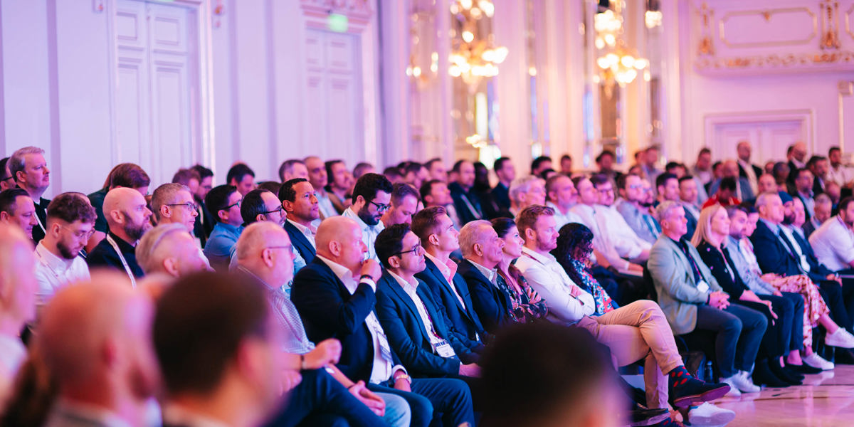 Delegates seated in an audience, attentively listening to a presentation at a conference