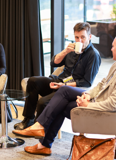 Three people sitting in chairs around a small round table