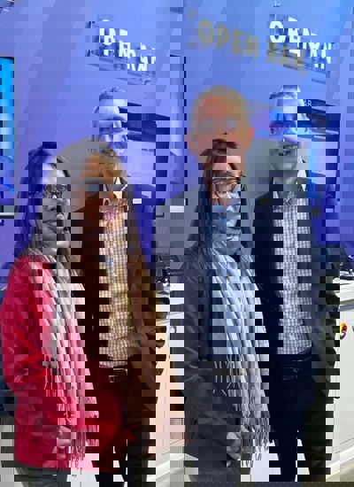Two people standing in front of a tradeshow booth