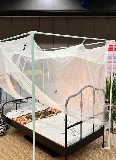 A four poster bed covered with a mosquito net