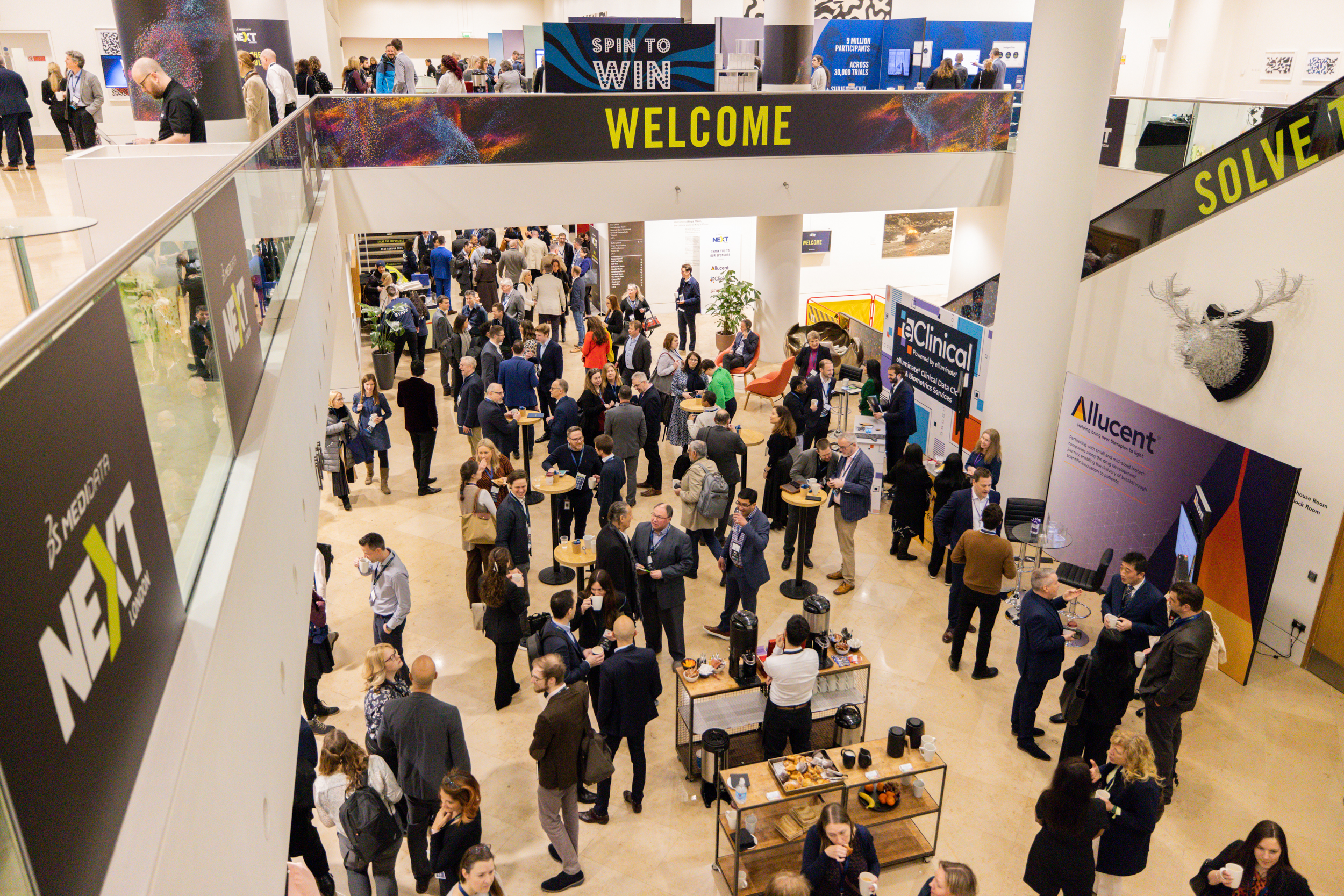 The entrance lobby of a conference centre with lots of people standing on two levels