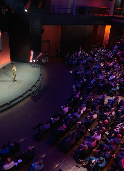 Audience in large auditorium watching a speaker present on stage at the cyber security event