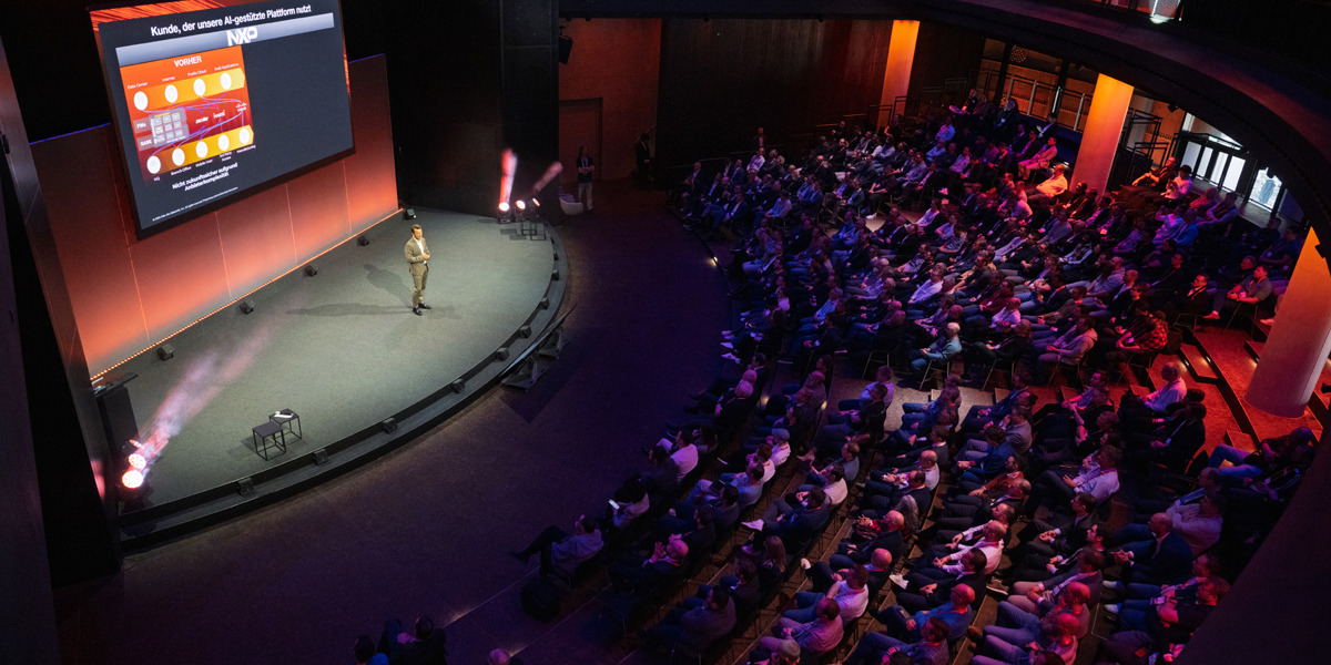 Audience in large auditorium watching a speaker present on stage at the cyber security event