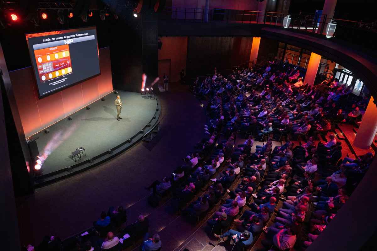 Audience in large auditorium watching a speaker present on stage at the cyber security event