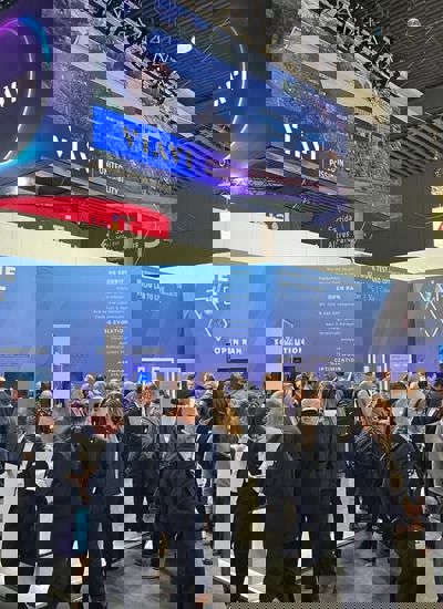People standing around a tradeshow booth displaying the VIAVI brand