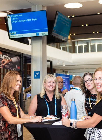 A group of smiling women standing at a poseur table