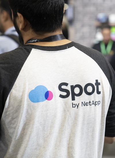 A bearded person seen from behind wearing a tshirt with Spot by NetApp written on it 