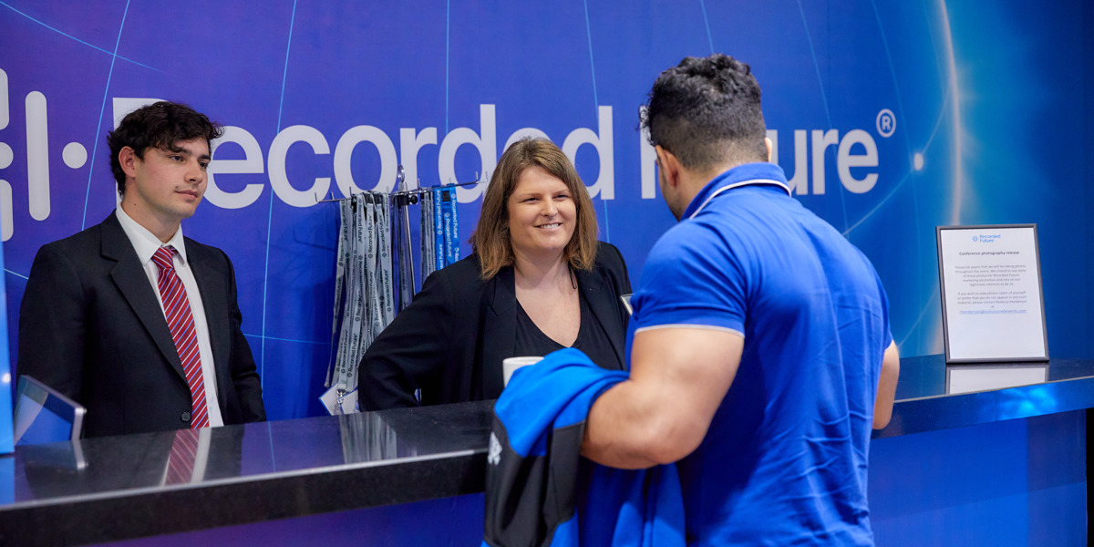 People talking at the Recorded Future event registration desk