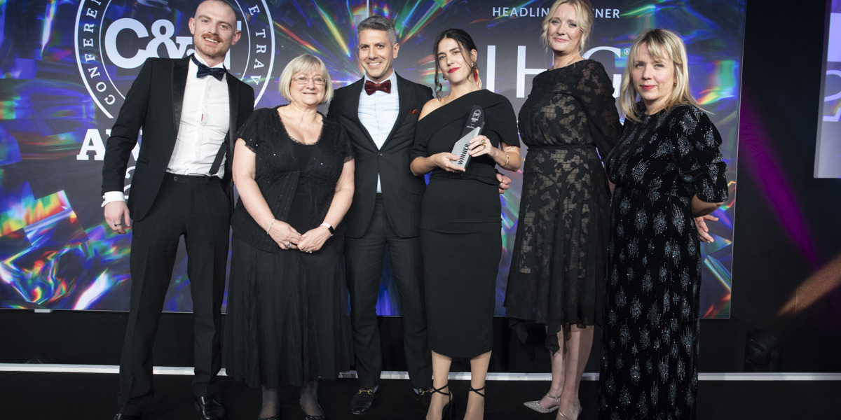 Outsourced Events team and clients smiling while holding the C&IT Award, celebrating their achievement